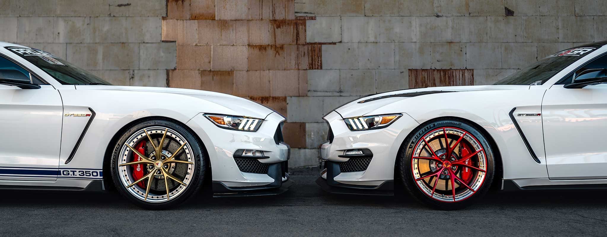 two white s550 ford mustangs with two piece forged project 6gr wheels in custom finish